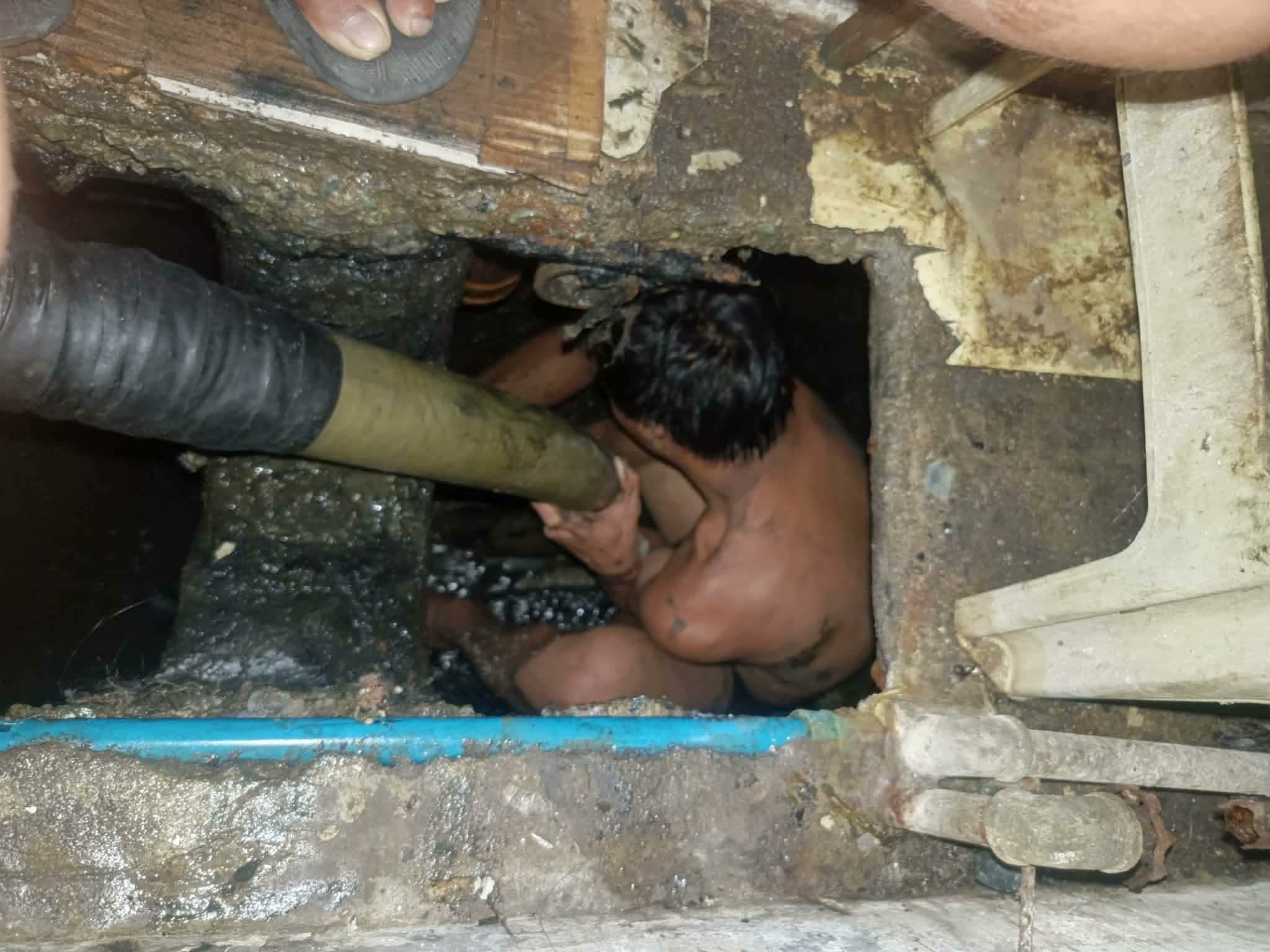 Crew cleaning the inside of a pozo negro
