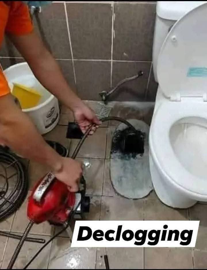 Crew declogging a floor drain