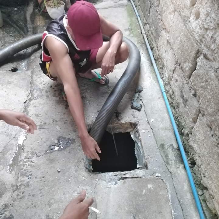 Siphoning hose drawing waste from a residential septic tank